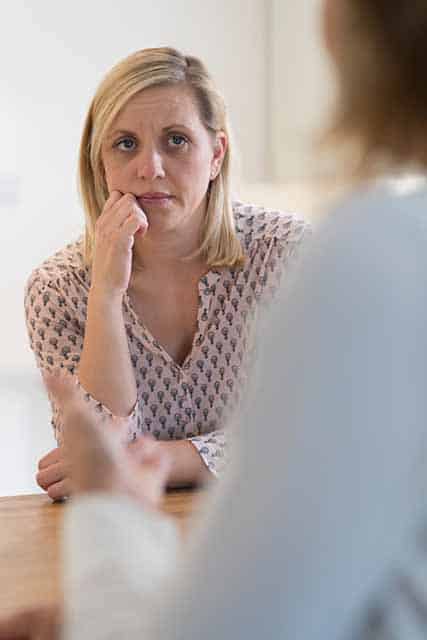 Psychologist providing therapy to parent with autistic child